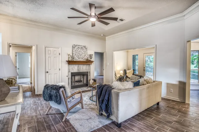 a living room with furniture a fireplace and a chandelier
