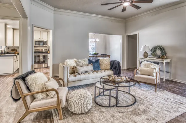 a living room with furniture a rug and white walls