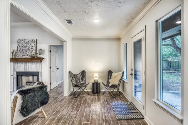 a living room with furniture a fireplace and a large window