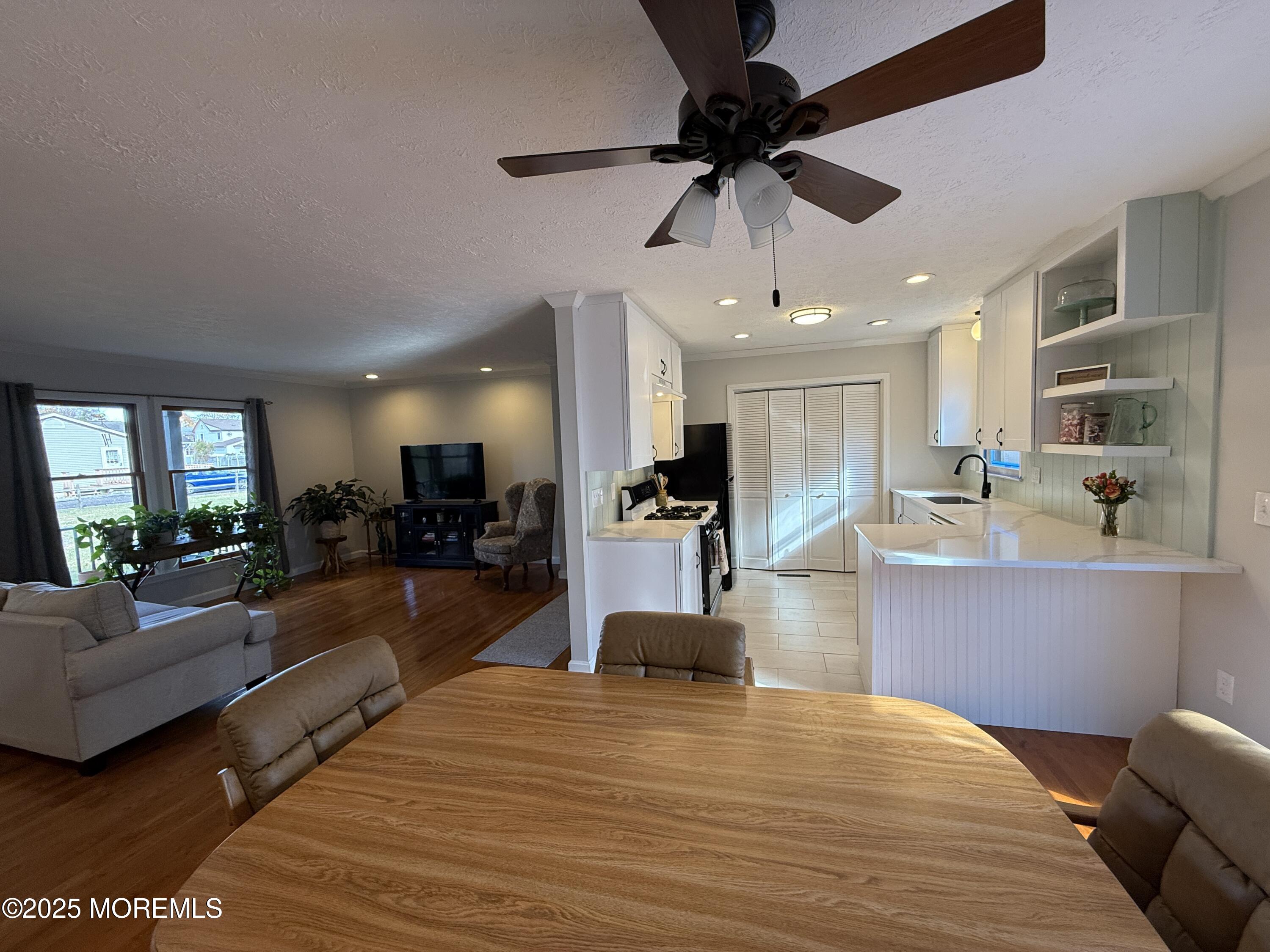 220 B Center Street Tuckerton, NJ 08087 - Photo 13 of 54 a large kitchen with stainless steel appliances kitchen island granite countertop a refrigerator a stove a sink dishwasher with a dining table and chairs with wooden floor