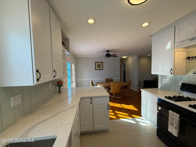 a view of kitchen with stainless steel appliances kitchen island sink stove and cabinets