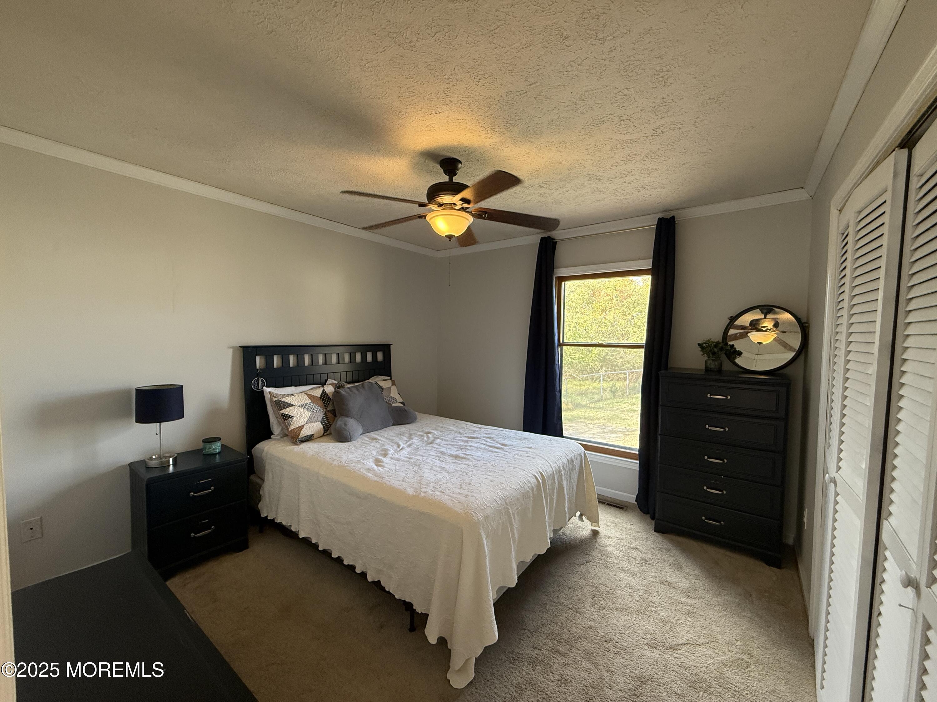 220 B Center Street Tuckerton, NJ 08087 - Photo 22 of 54 a bedroom with a bed and a chandelier