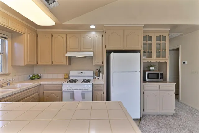 a kitchen with stainless steel appliances a refrigerator sink and cabinets