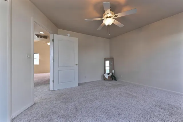 wooden floor in an empty room with a chandelier fan