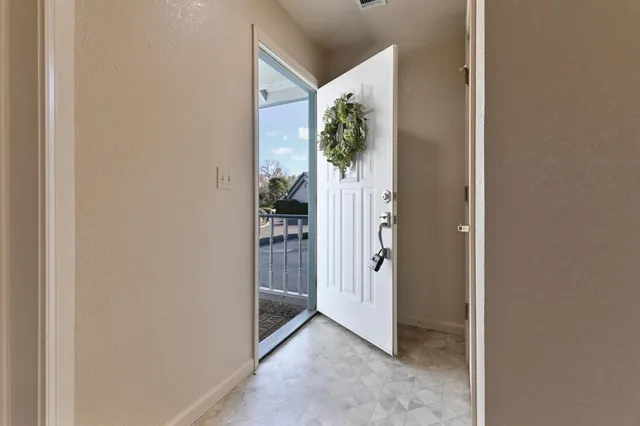 a view of a hallway with wooden floor and a living room