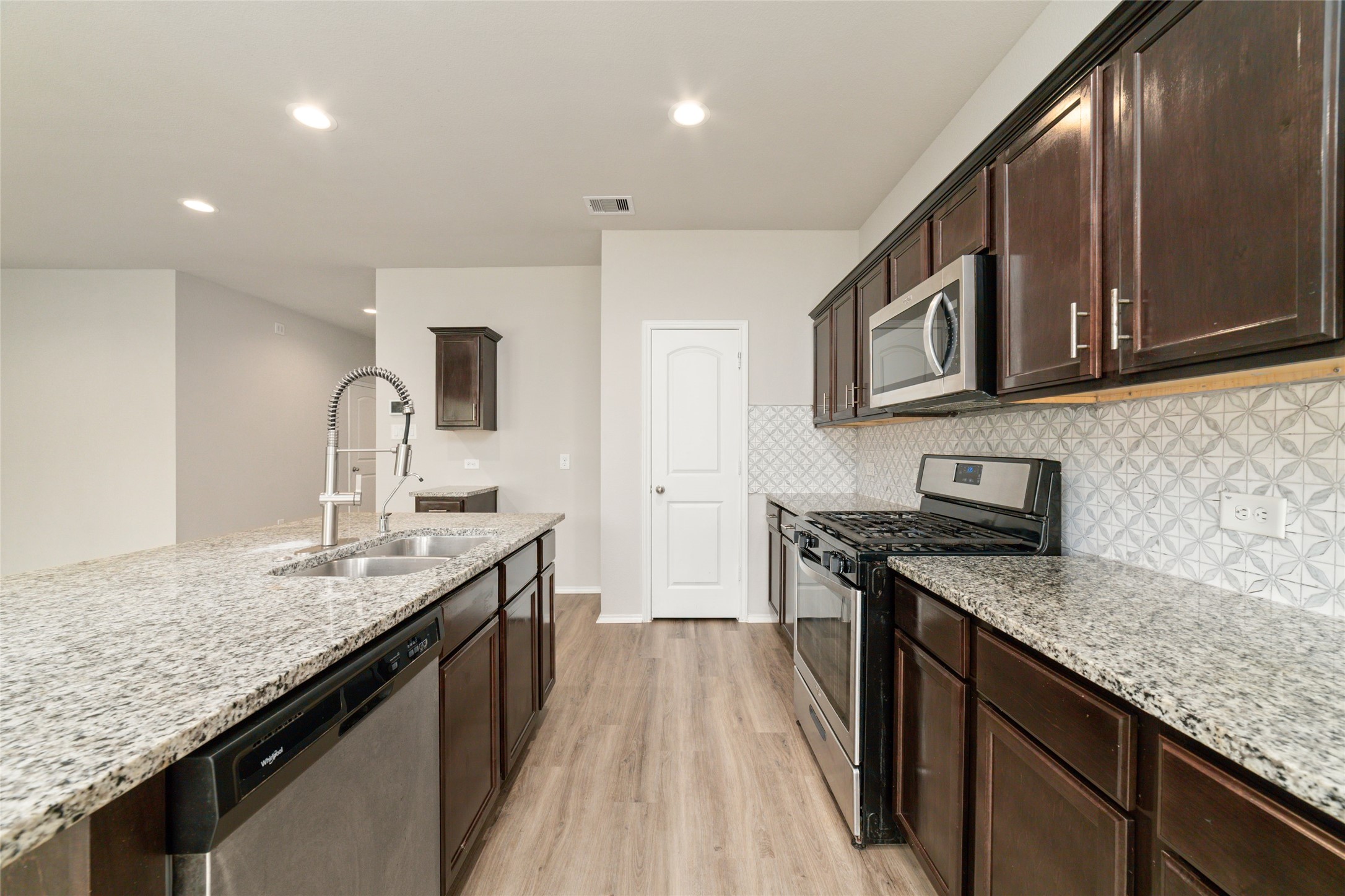 23702 Harrow Field Ln Spring Spring, TX 77373 - Photo 13 of 32 a kitchen with stainless steel appliances granite countertop a sink stove and refrigerator