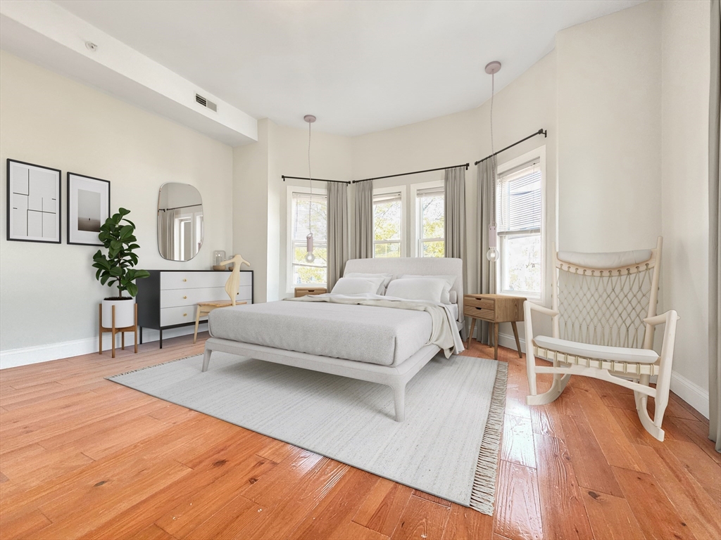 a bedroom with a bed couch and windows
