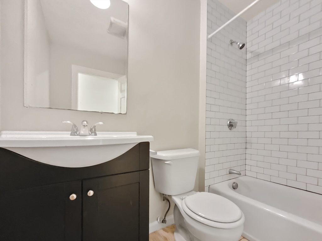 26 Arcadia Street, Unit 1R Boston, MA 02122 - Photo 7 of 7 a bathroom with a sink a toilet and shower