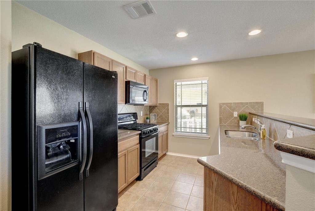 201 Edwin Kyle, TX 78640 - Photo 8 of 21 a kitchen with stainless steel appliances granite countertop a refrigerator a sink a stove and island