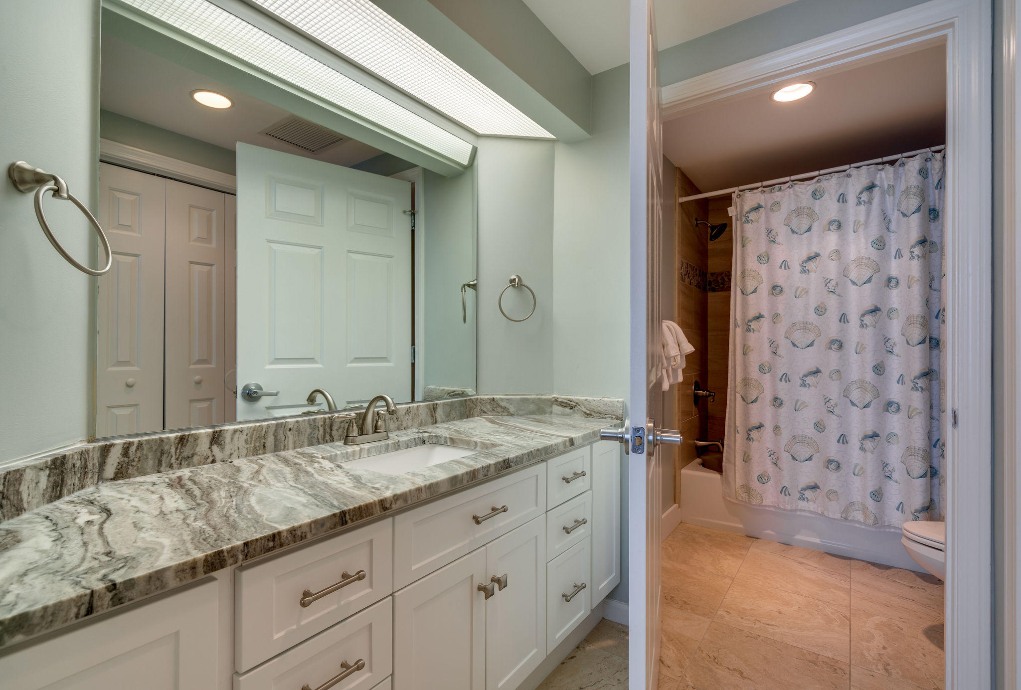 4807 Westwinds Drive, Unit 4807 Miramar Beach, FL 32550 - Photo 14 of 19 a bathroom with a granite countertop sink a mirror a shower and a bathtub