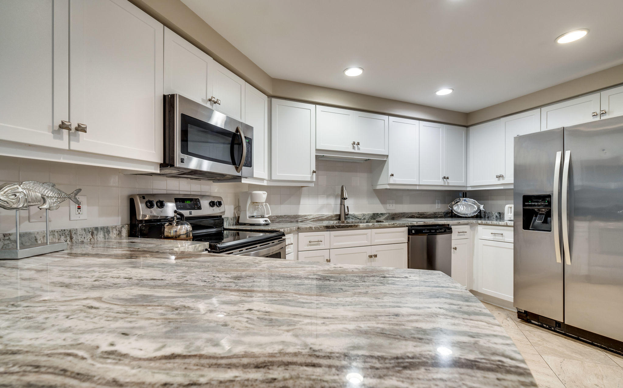 4807 Westwinds Drive, Unit 4807 Miramar Beach, FL 32550 - Photo 7 of 19 a kitchen with stainless steel appliances granite countertop a stove a sink dishwasher a refrigerator and a microwave