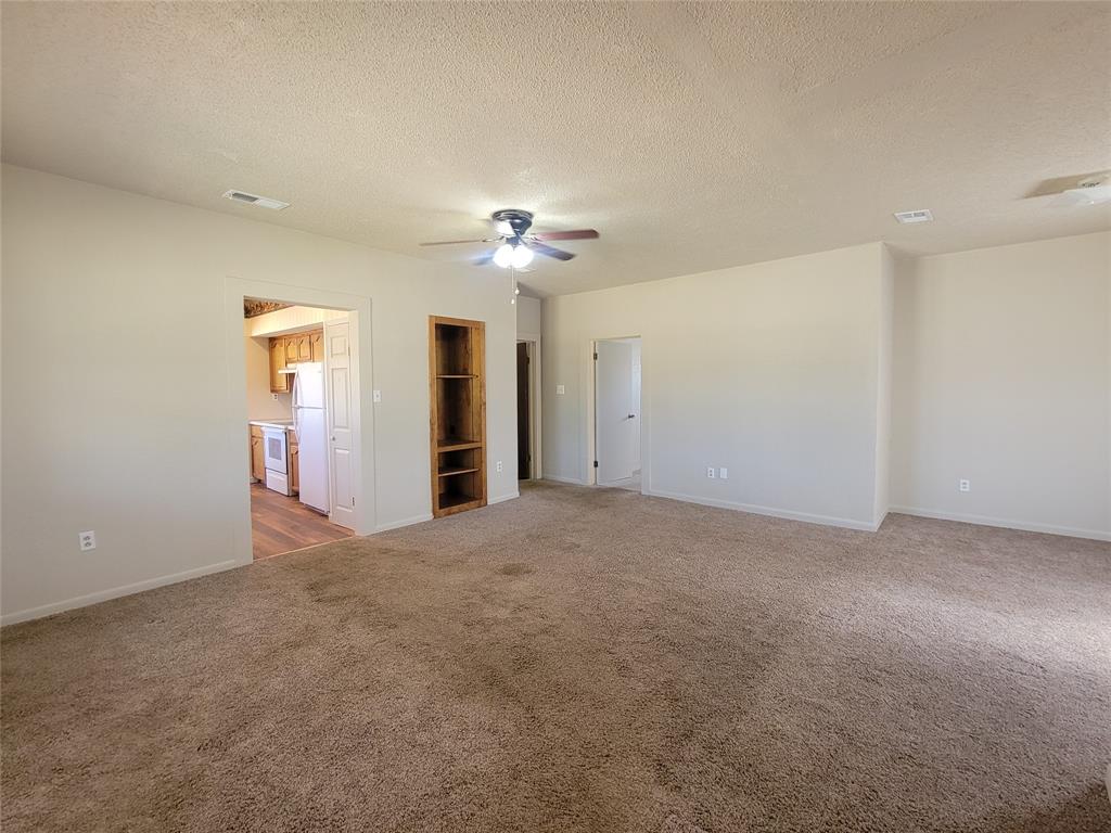 215 Cedar Court Graham, TX 76450 - Photo 12 of 39 a view of an empty room with a ceiling fan