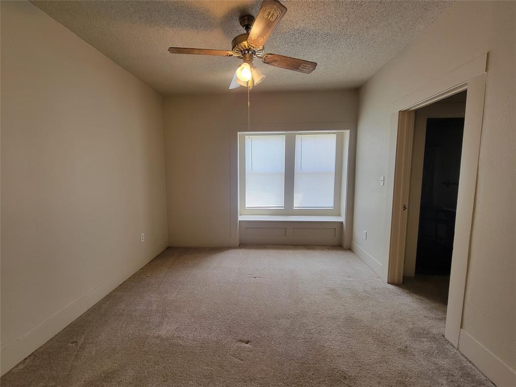 215 Cedar Court Graham, TX 76450 - Photo 21 of 39 an empty room with chandelier fan and windows