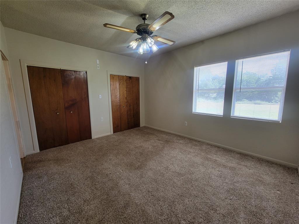 215 Cedar Court Graham, TX 76450 - Photo 25 of 39 a view of an empty room with window and chandelier fan