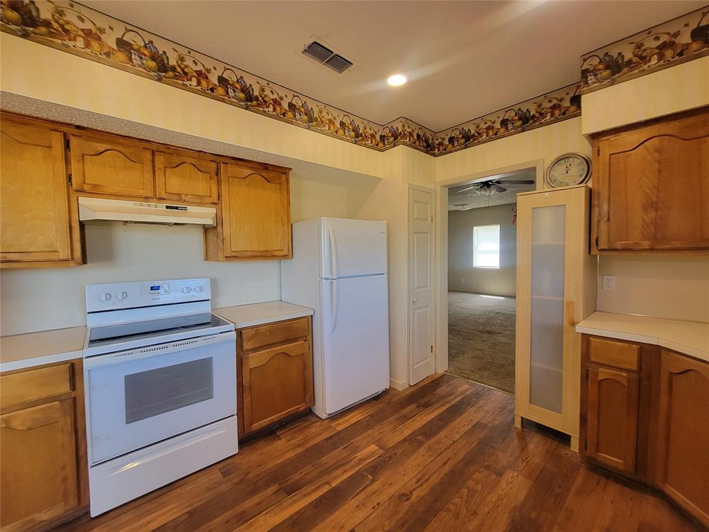 215 Cedar Court Graham, TX 76450 - Photo 33 of 39 a kitchen with granite countertop wooden floors and stainless steel appliances