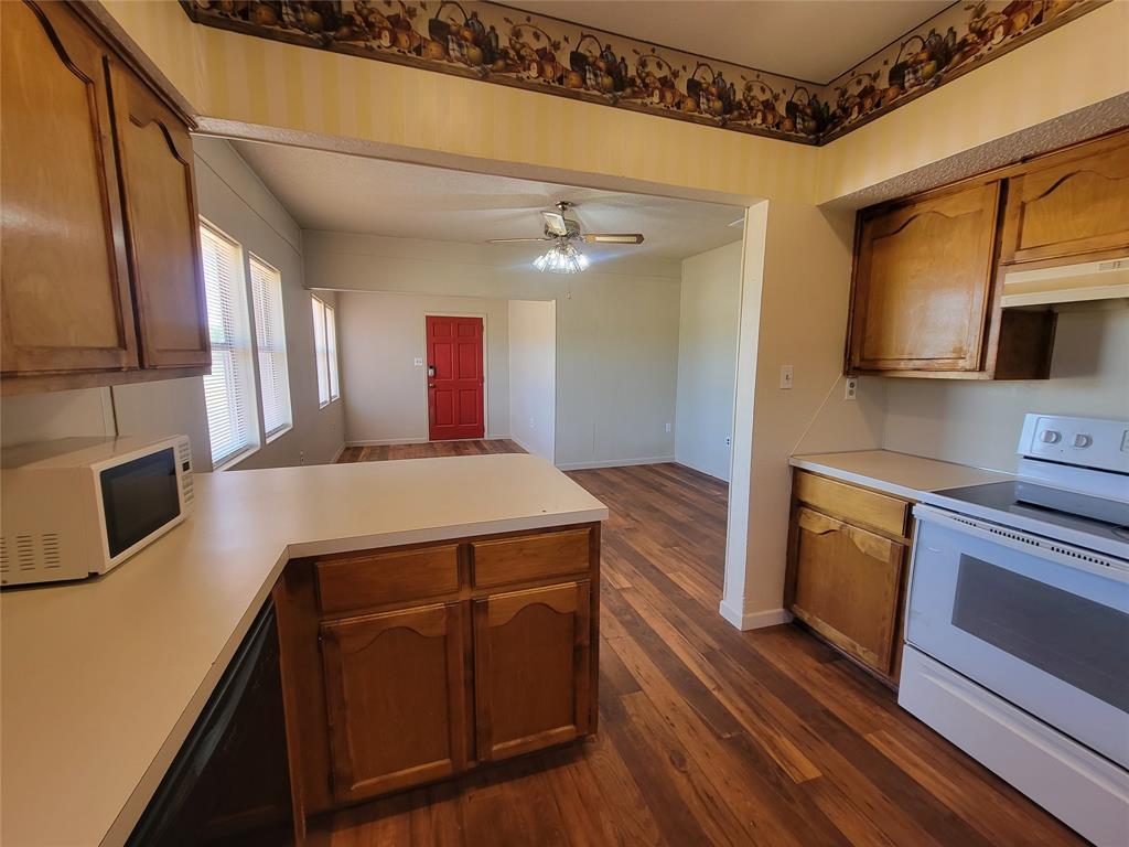 215 Cedar Court Graham, TX 76450 - Photo 34 of 39 a kitchen with stainless steel appliances granite countertop a sink a stove microwave and cabinets