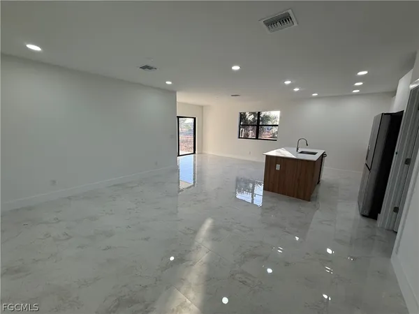an empty room with wooden floor and a ceiling fan
