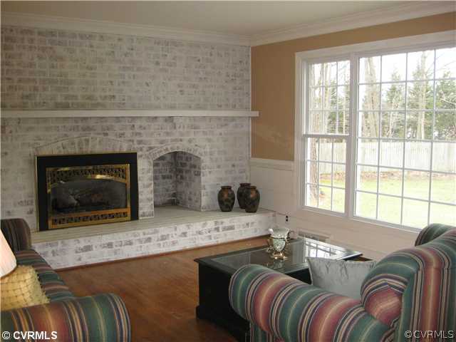 10830 Cherokee Road Midlothian, VA 23113 - Photo 13 of 17 a living room with furniture a flat screen tv and a fireplace