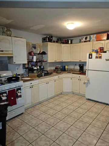 a kitchen with granite countertop cabinets sink and white appliances