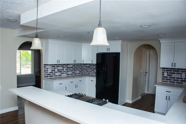 a kitchen with stainless steel appliances a refrigerator and a stove top oven