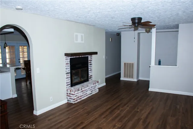 a view of empty room with wooden floor and fireplace