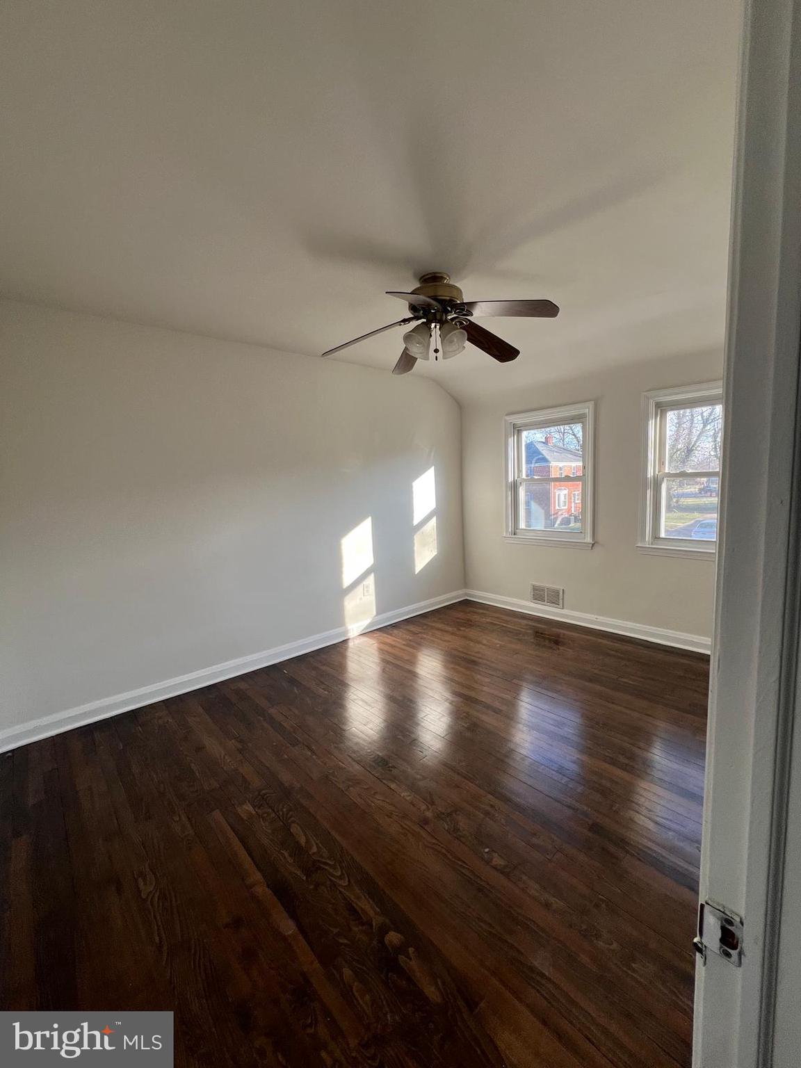 603 Braeside Road Baltimore, MD 21229 - Photo 16 of 30 an empty room with wooden floor and windows