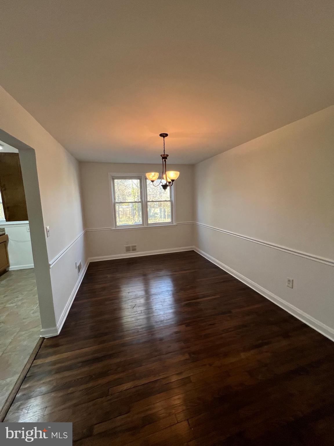 603 Braeside Road Baltimore, MD 21229 - Photo 18 of 30 an empty room with wooden floor and windows