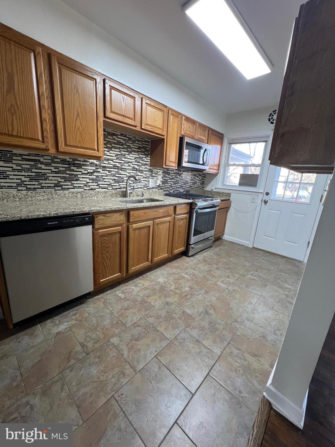 603 Braeside Road Baltimore, MD 21229 - Photo 3 of 30 a kitchen with stainless steel appliances granite countertop a sink stove and cabinets