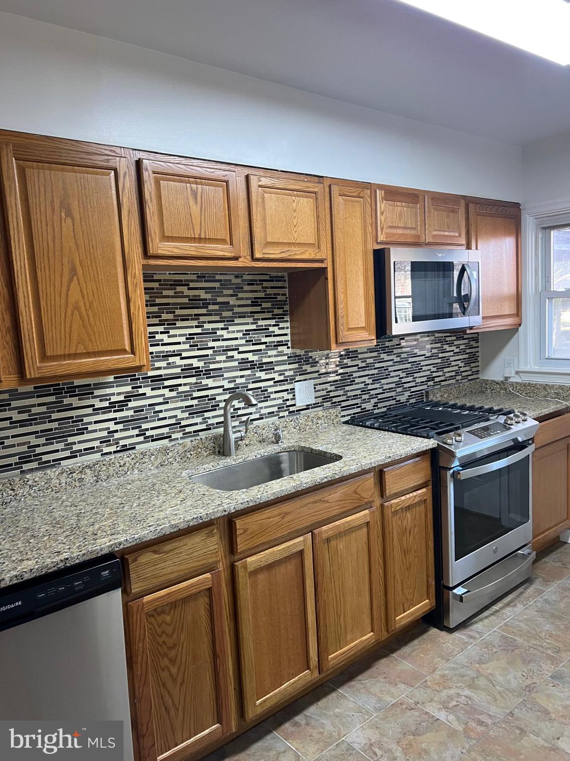 603 Braeside Road Baltimore, MD 21229 - Photo 4 of 30 a kitchen with stainless steel appliances granite countertop a sink stove and cabinets