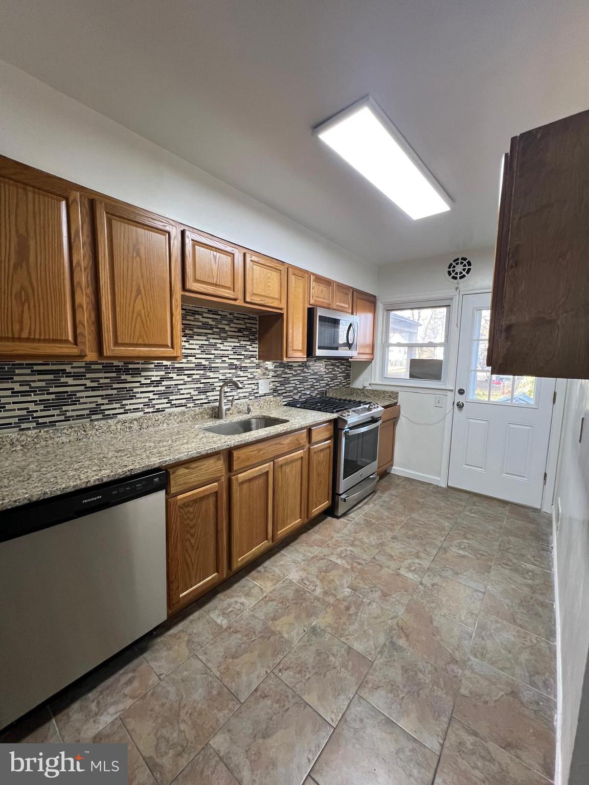 603 Braeside Road Baltimore, MD 21229 - Photo 8 of 30 a kitchen with stainless steel appliances granite countertop a stove sink and cabinets