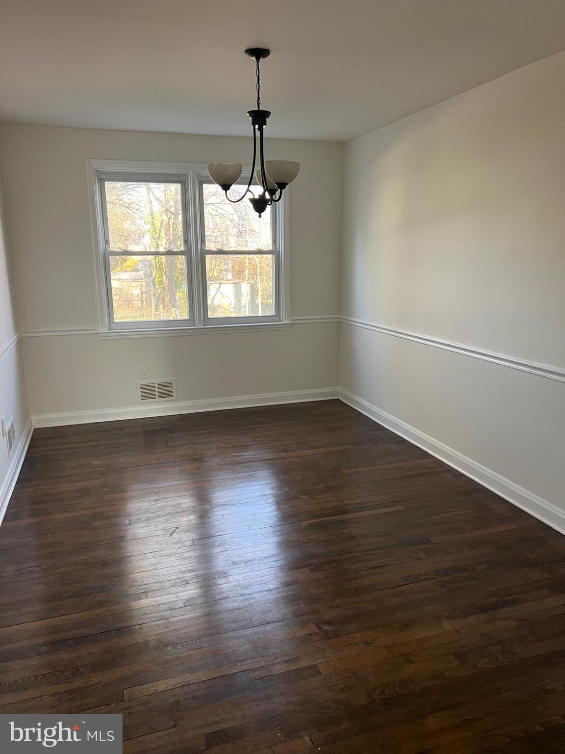 603 Braeside Road Baltimore, MD 21229 - Photo 10 of 30 an empty room with wooden floor and windows