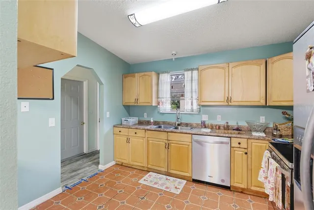 a kitchen with stainless steel appliances granite countertop a sink and dishwasher a stove top oven with white cabinets