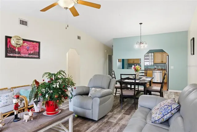 a view of a dining room with furniture a chandelier and wooden floor