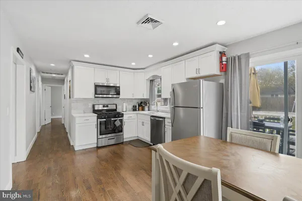 a kitchen with stainless steel appliances granite countertop a refrigerator a stove top oven a sink and dishwasher