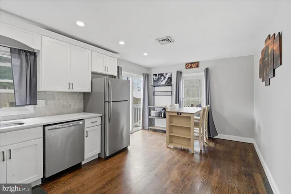 a kitchen with white cabinets and stainless steel appliances