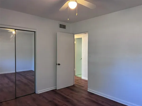 an empty room with wooden floor and closet