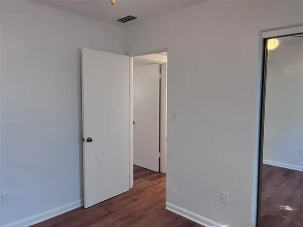 a view of an empty room with wooden floor