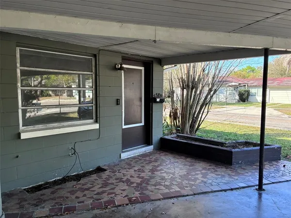 a view of a porch with a table and chairs