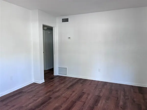 a view of an empty room with wooden floor