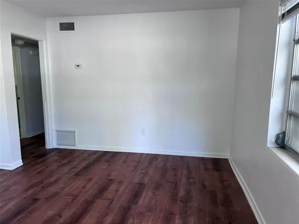 a view of a room with wooden floor and a window