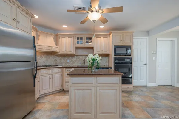 a kitchen with kitchen island granite countertop cabinets and refrigerator