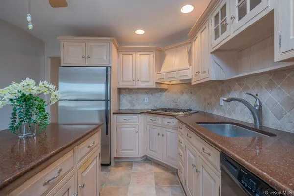 a kitchen with granite countertop a sink stainless steel appliances and cabinets