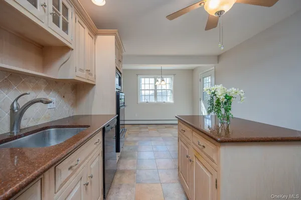 a kitchen with stainless steel appliances granite countertop a sink a stove and a wooden floors