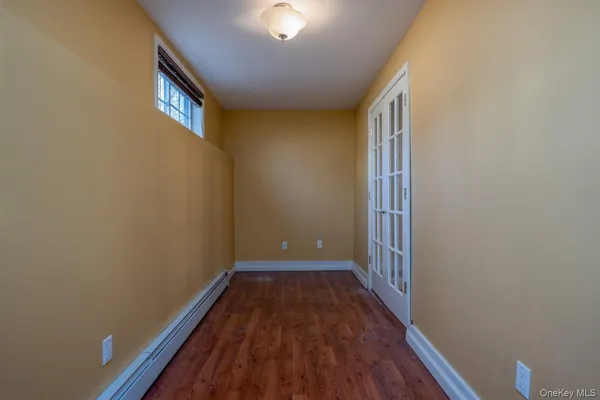 a view of a room with wooden floor and a window