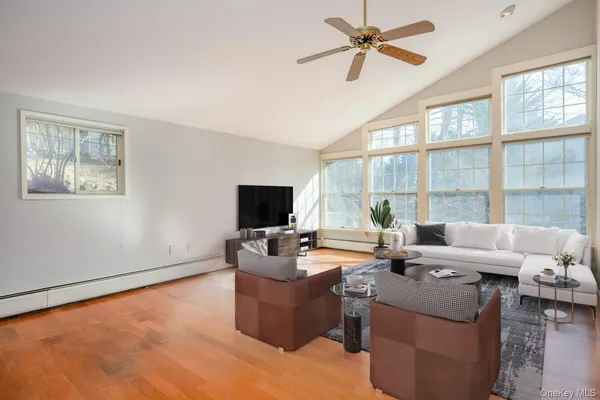a living room with furniture a large window and a flat screen tv