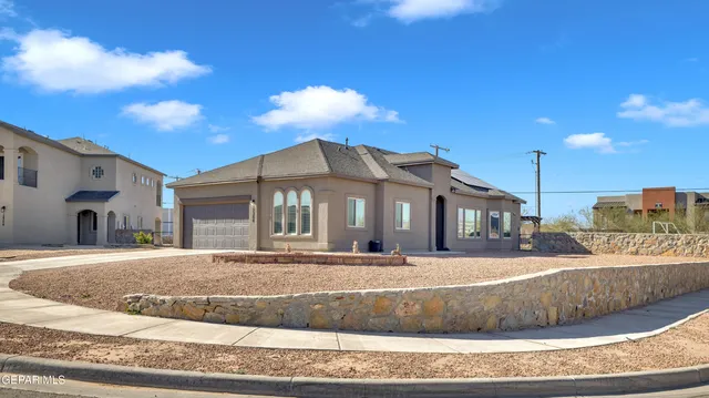 a view of a white house with a yard and table and chairs