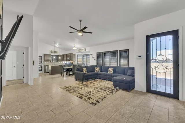 a living room with furniture large window and wooden floor