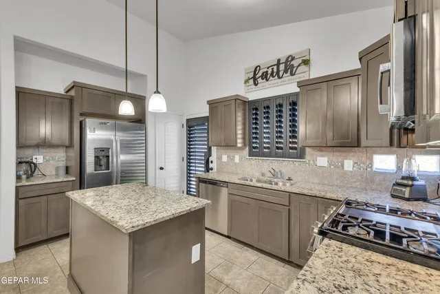 a kitchen with a stove kitchen island and couches with wooden floor