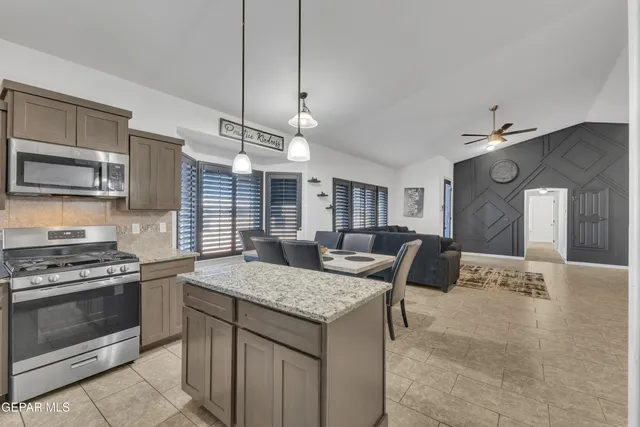 a kitchen with stainless steel appliances granite countertop a sink a stove and oven