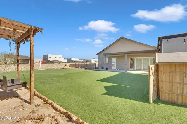 a view of a house with a yard and a large tree